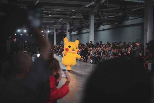 Pikachu walking by rows of fans.